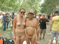 Young girl at a nudist festival with firm tits and shaved cunt posing with older guy with fat shave dick