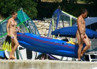 Young nude couple with guy's hard small hairy penis and girl with firm tits and shaved cunt taking boat to water